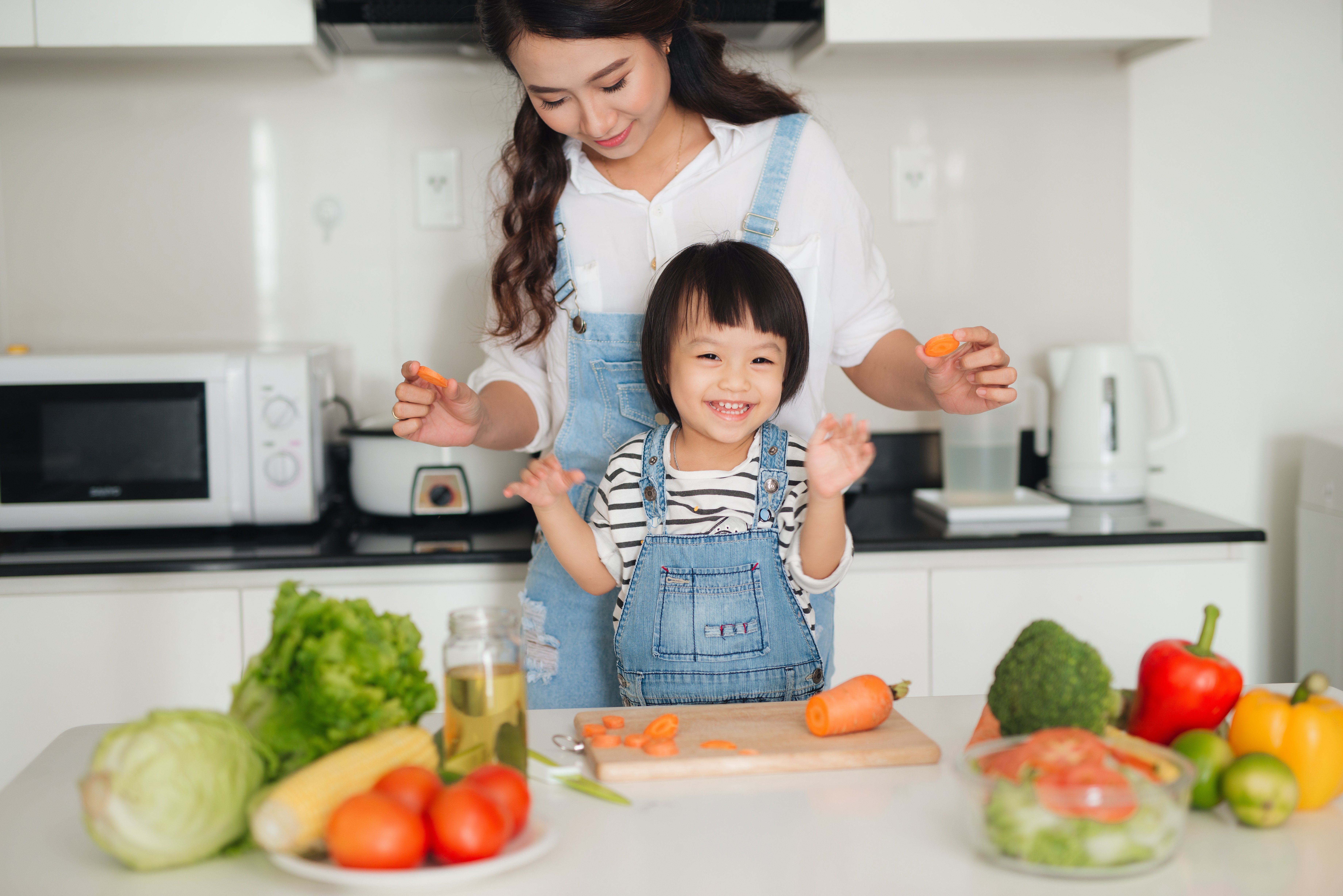 Mom-and-daughter-chopping-carrots-in-kitchen